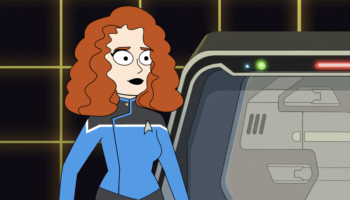 It's an image of me from the waist up from the Star Trek Lower Decks character creator. I've got big bushy red hair and am wearing a science uniform. I'm inside a blank holodeck room and you can see the exit door to my right.