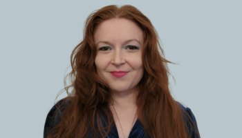 A photo of myself from the chest up I took for my LinkedIn profile. I'm a white woman with long red hair, in full makeup.